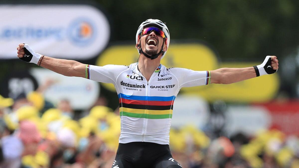 Quick-Step rider Julian Alaphilippe of France celebrates as he crosses the finish line to win the first stage. (Reuters)