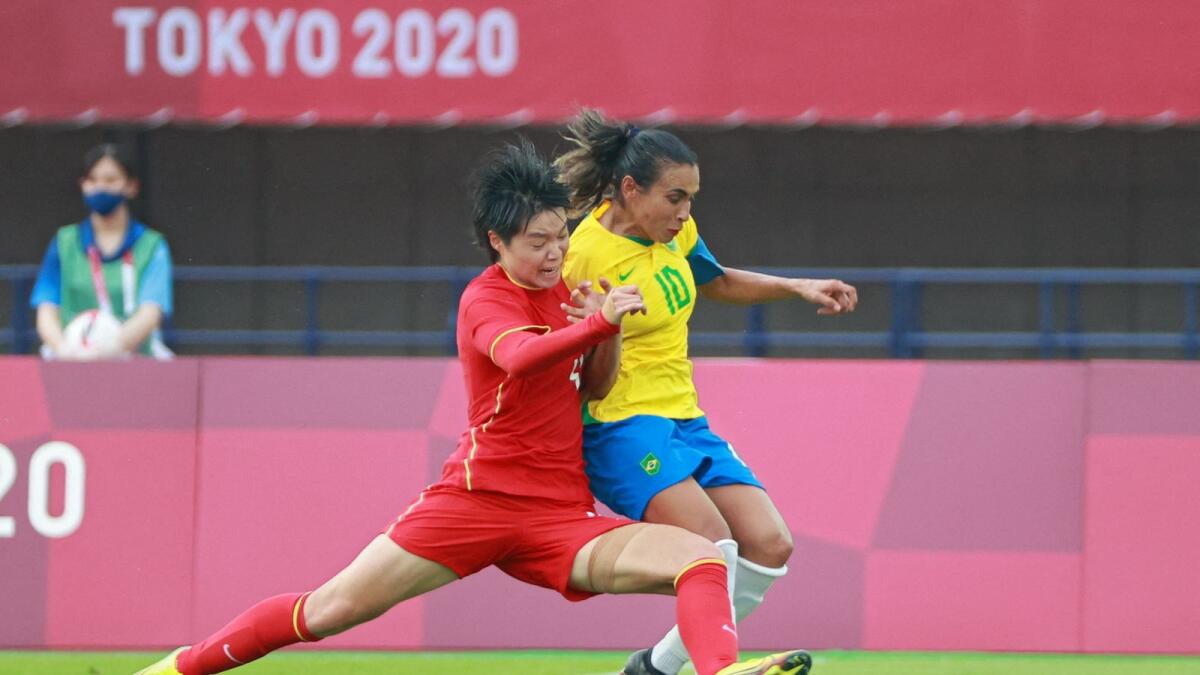 China's midfielder Li Qingtong (left) vies for the ball with Brazil's Marta during the women's football match at the 2020 Tokyo Olympic Games in Miyagi on Wednesday. (AFP)
