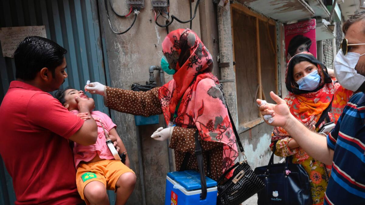 A health worker administers polio vaccine drops to a child during a polio vaccination door-to-door campaign in Lahore. Pakistan on July 20 resumed its polio vaccination campaign after a four-month pause due to the coronavirus outbreak, with health authorities predicting a surge in cases of the crippling disease. Photo: AFP