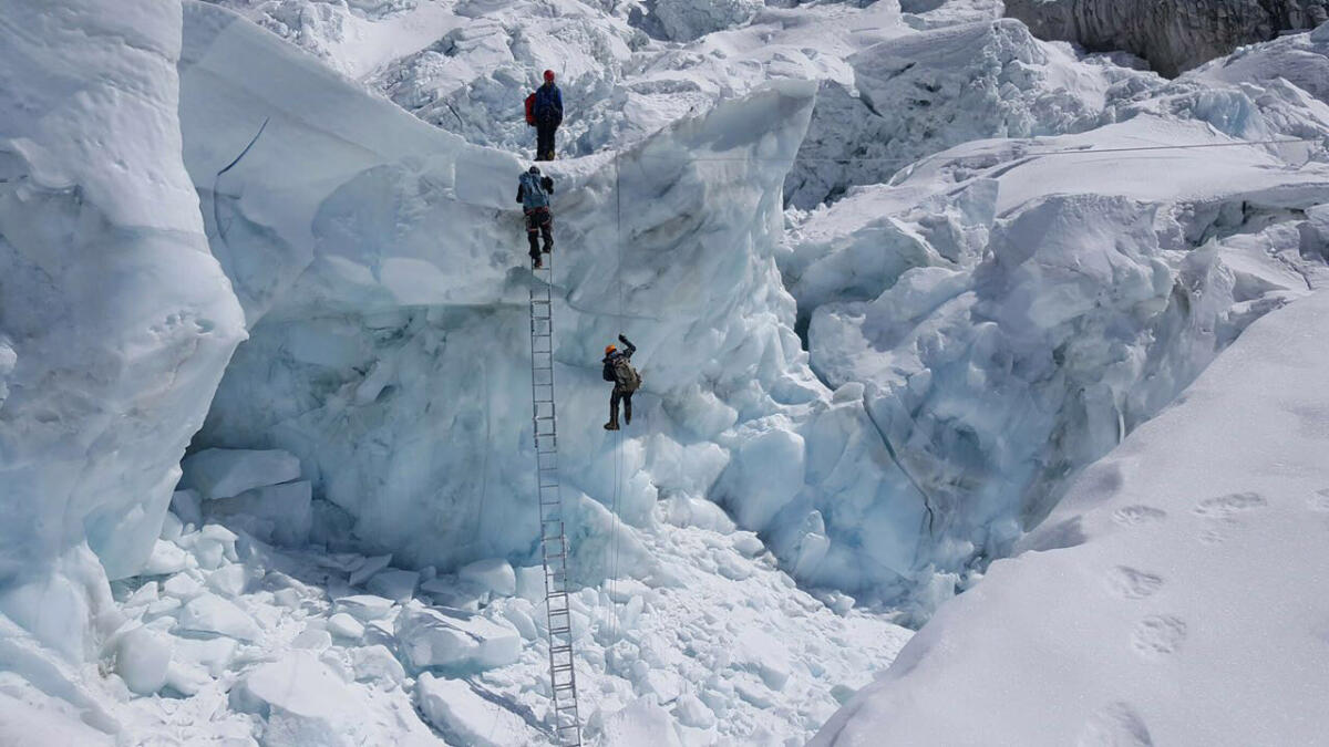 Braving the weather conditions the climbers scale the Everest. — Wam