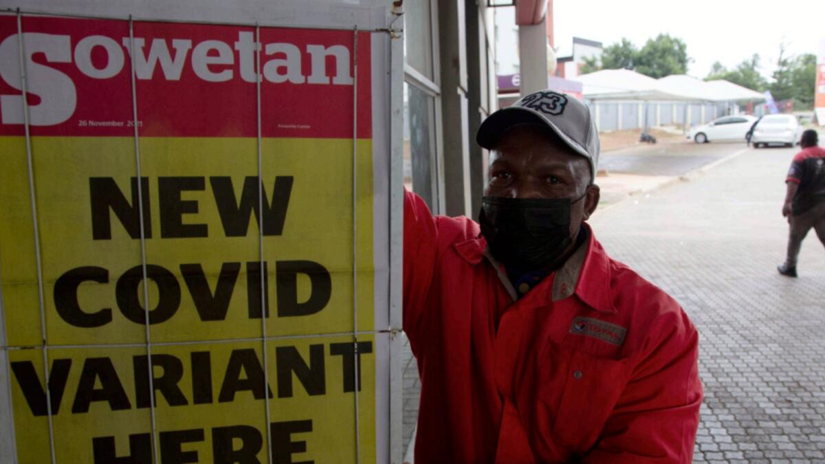 A petrol attendant stands next to a newspaper headline in Pretoria, South Africa. — AP