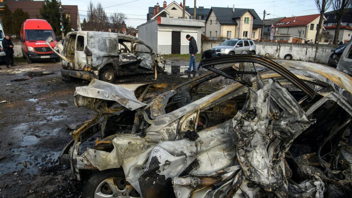 A man walks next to a car destroyed during a Russian missile and drone strike in Kyiv. — Reuters