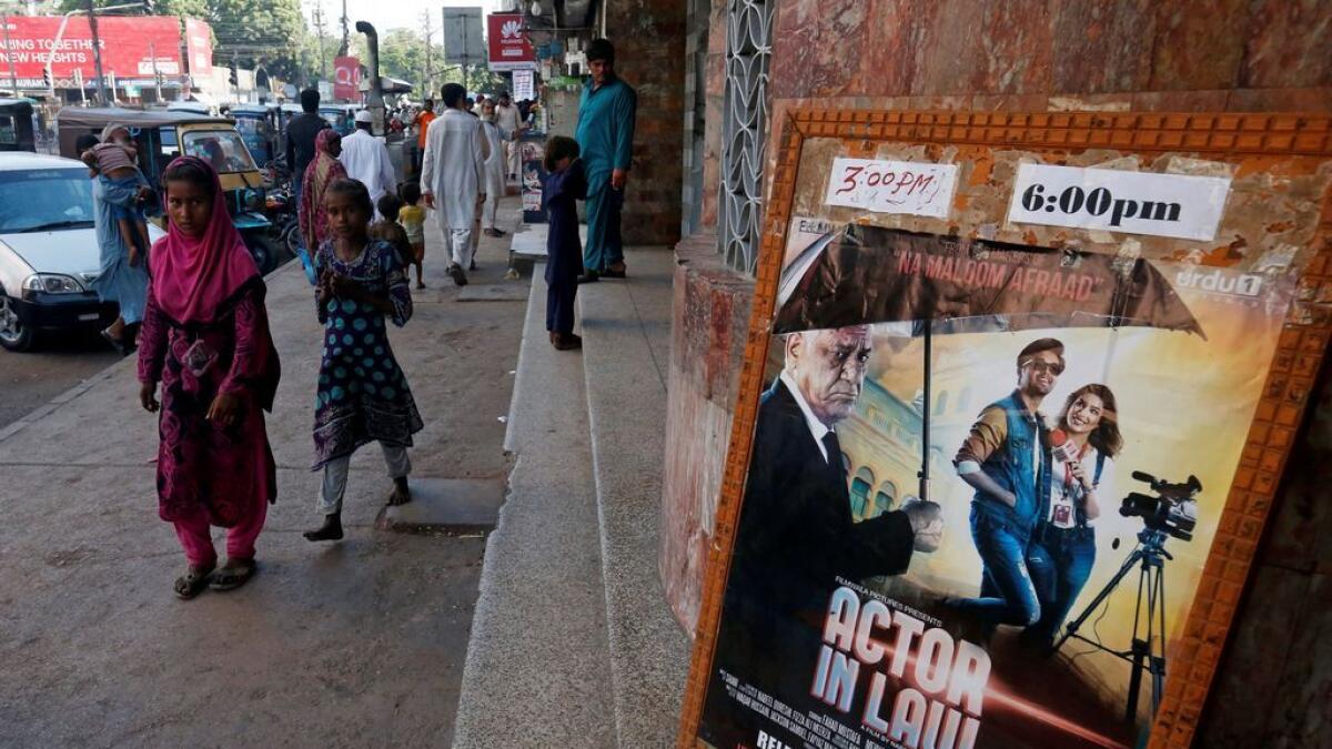 An advertising poster for a Pakistani film with Indian actors is seen outside a movie theater in Karachi, Pakistan