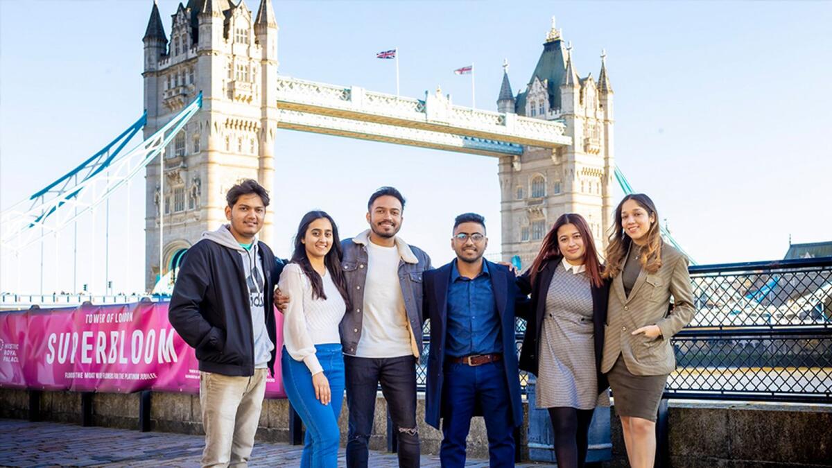 Coventry University London students posing near Tower Bridge in London, UK.