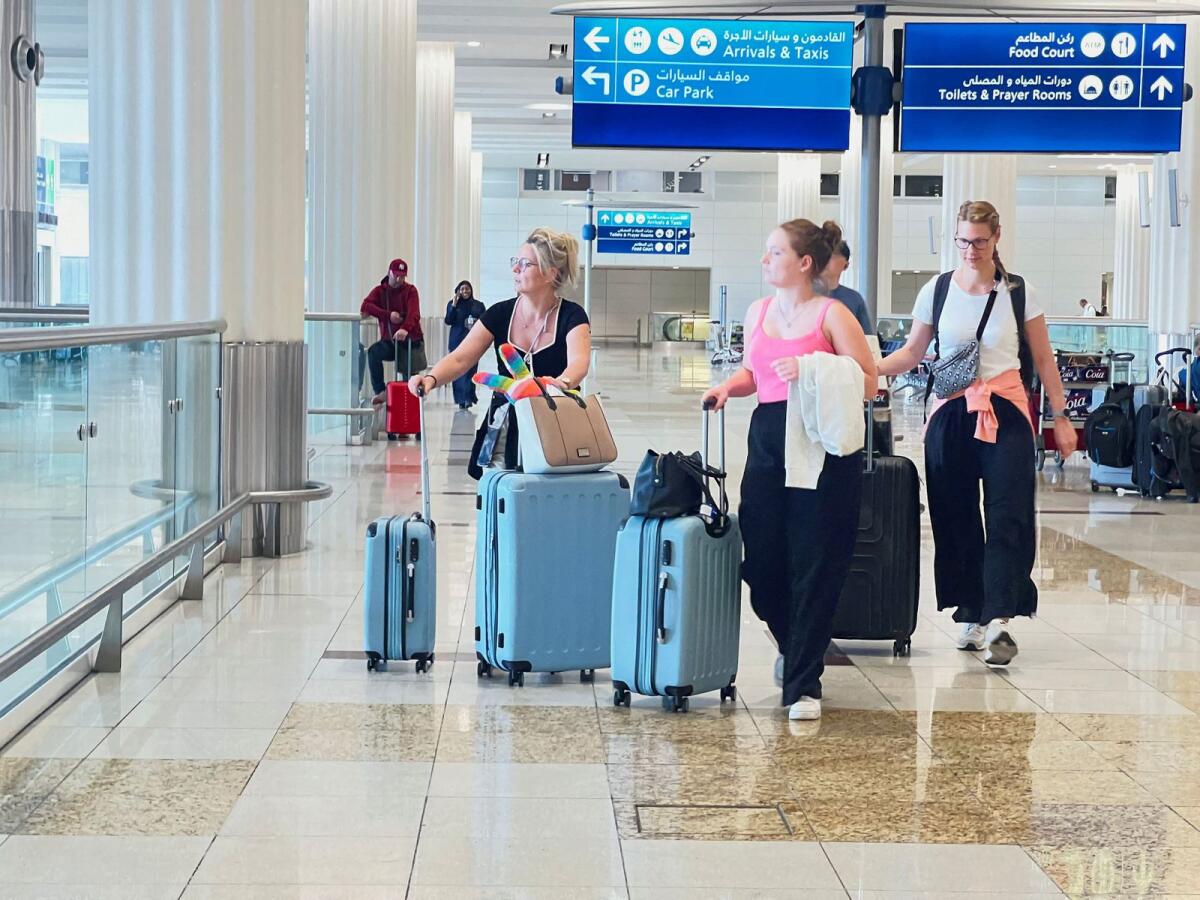 People walk with their luggage after a rainstorm hit Dubai, causing delays at Dubai International Airport on April 17. — Photo: Reuters