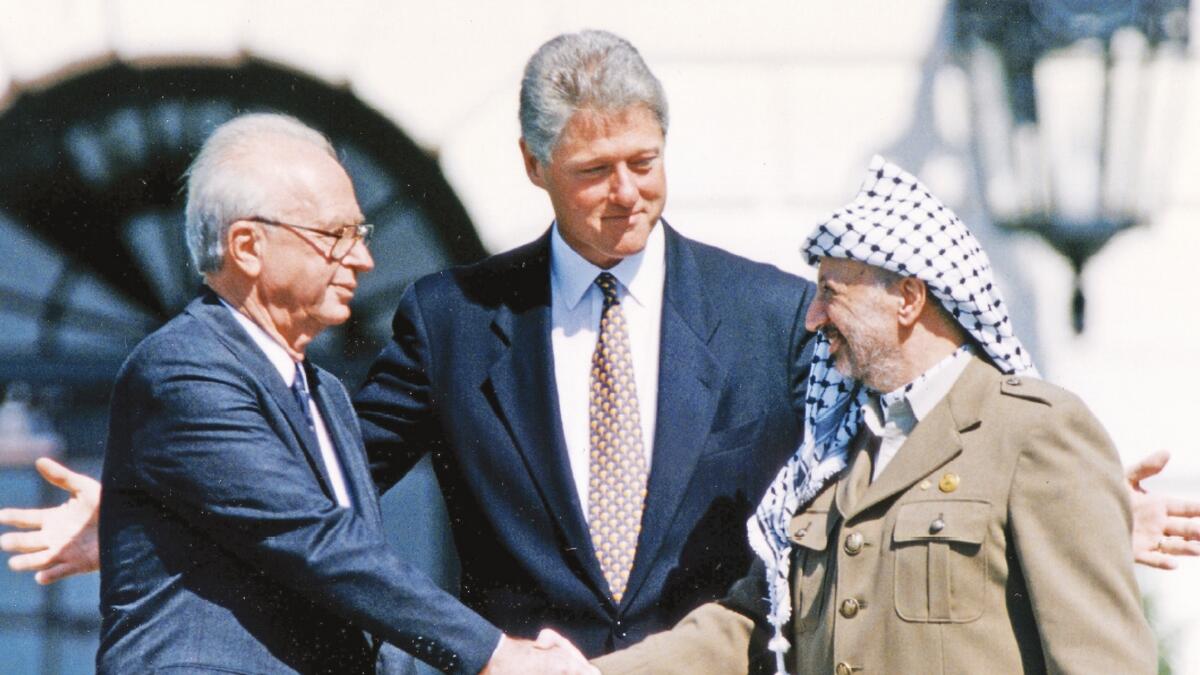 BURYING THE HATCHET: Former PLO chairman Yasser Arafat shakes hands with ex-Israeli prime minister Yitzhak Rabin after signing a peace accord as then US president Bill Clinton looks on.