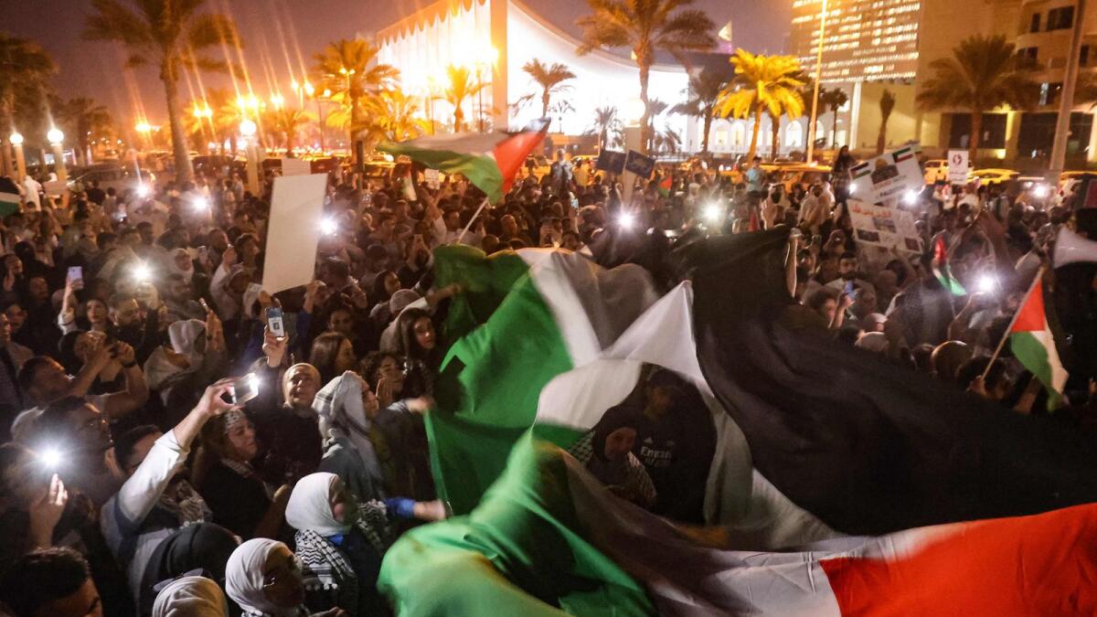 People deploy a large Palestinian flag during a march to show solidarity with the West Bank and the Gaza Strip, in Kuwait City. — AFP