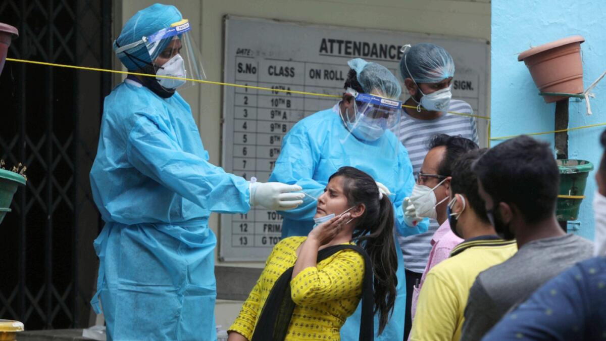 A woman reacts as a health worker tries to take her swab sample to test for Covid-19 in Jammu. — AP