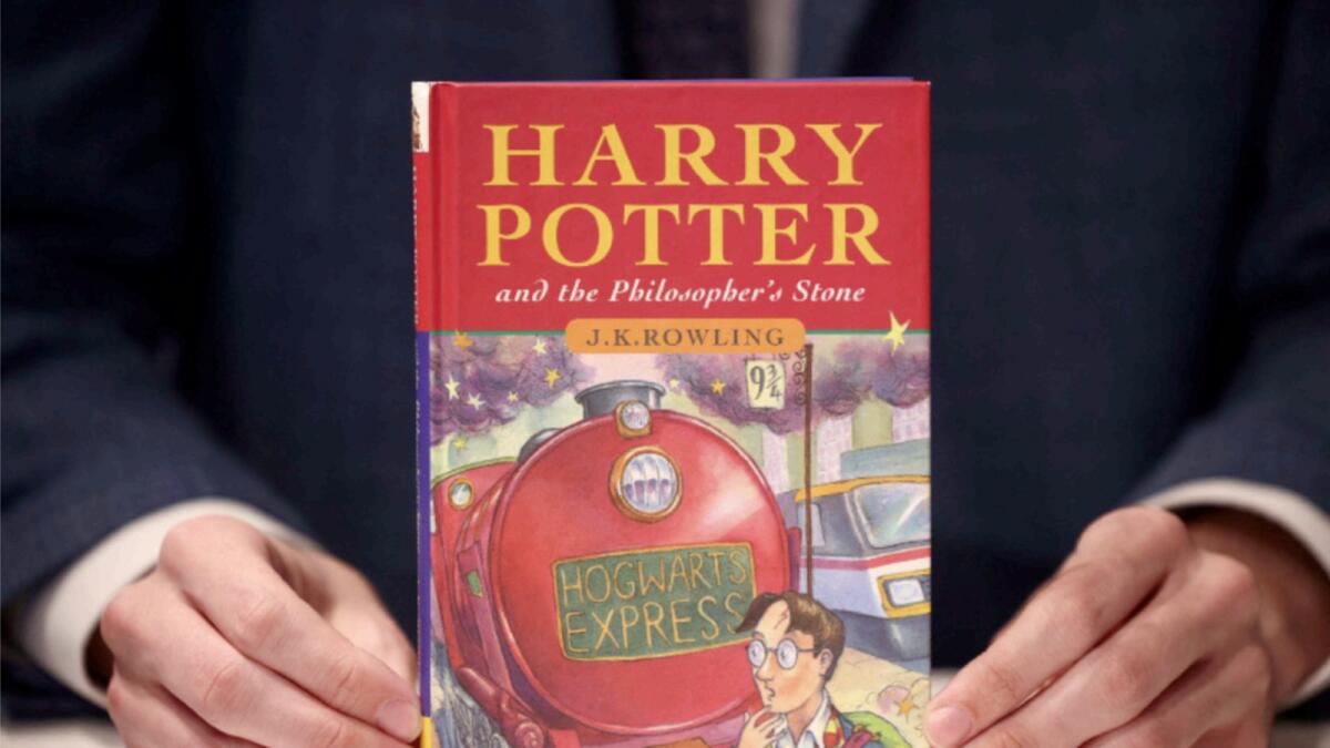 A person holds a rare first edition and signed by the author copy of 'Harry Potter and the Philosophers Stone' by British author J.K. Rowling, which is to be put up for auction at Christie's auction house in London. — Reuters