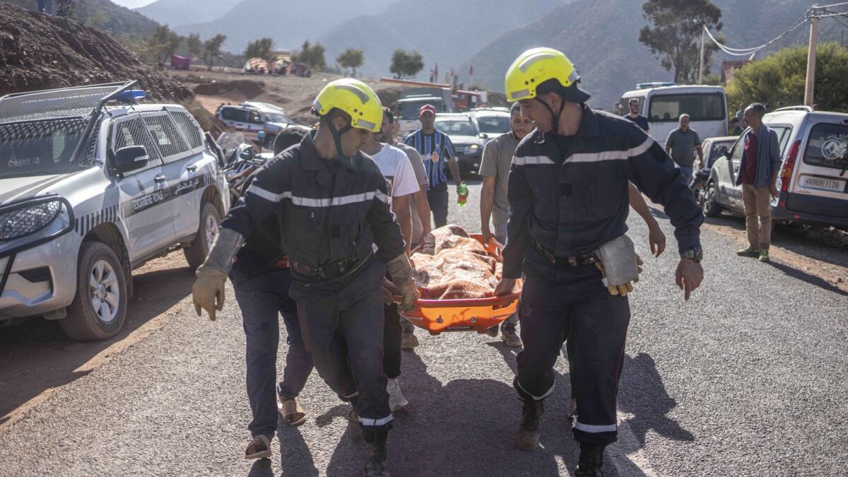 Members of rescue teams carry the body of a victim of an earthquake in Ouargane village, near Marrakech. — AP