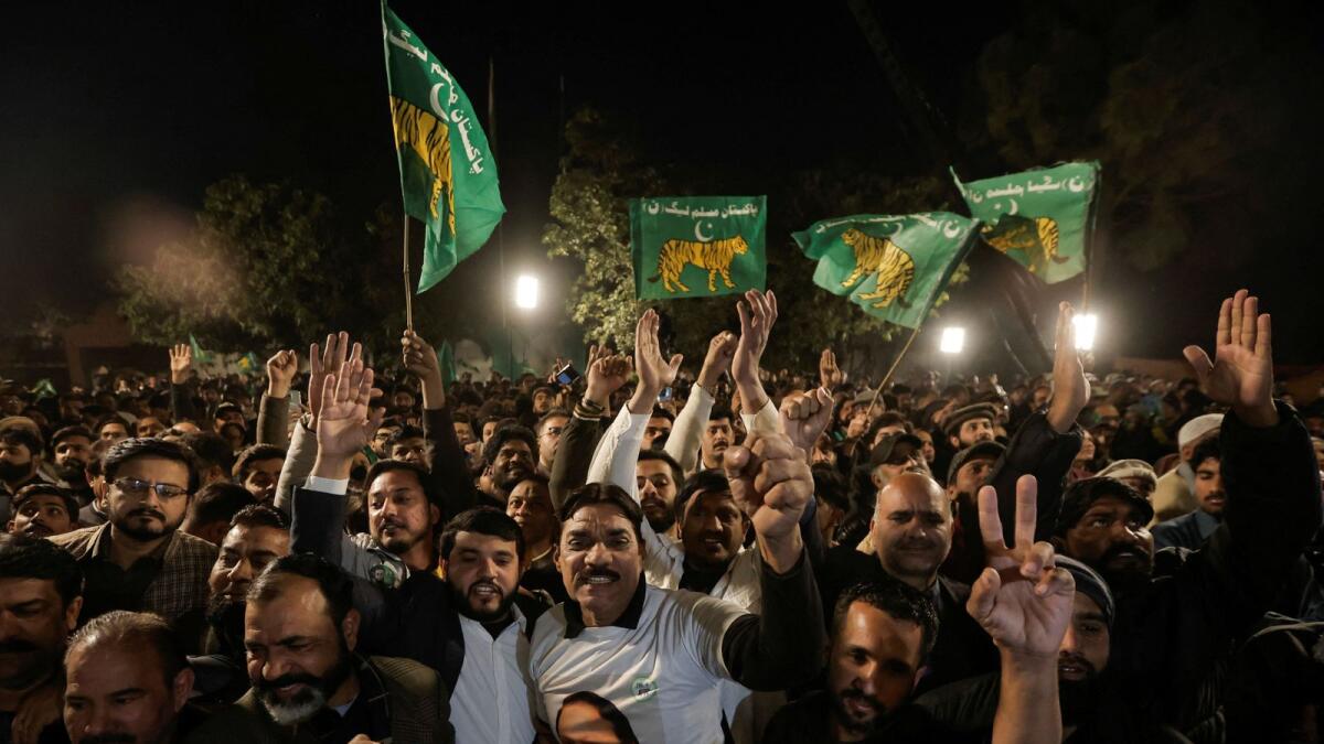 Supporters of Nawaz Sharif cheer as they gather at the party office of Pakistan Muslim League (N) at Model Town in Lahore. — Reuters