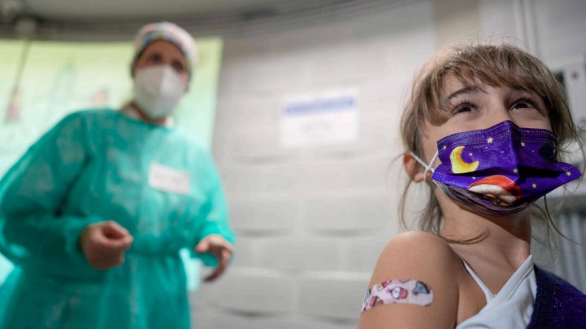 A girl shows a bandaid she received after having a dose of Pfizer-BioNTech Covid-19 vaccination for children aged 5 - 11, in Rome. — AP