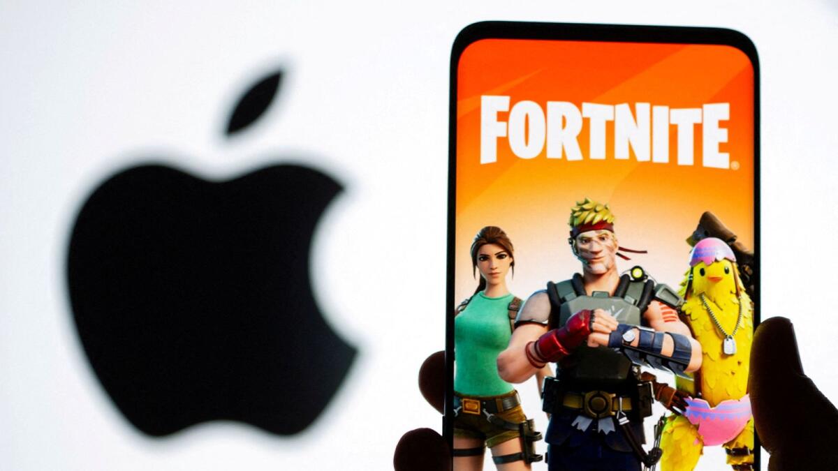 Fortnite game graphic is displayed on a smartphone in front of Apple logo. — Reuters file