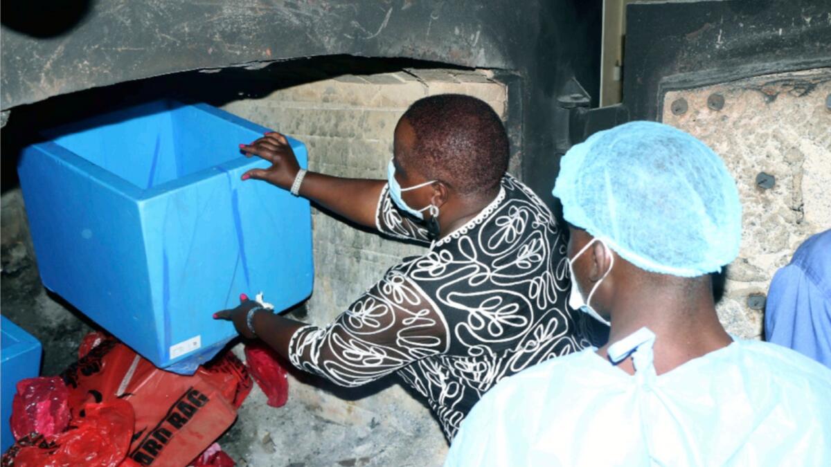 Malawi's Minister of Health Khumbize Chiponda places Covid-19 vaccines in an incinerator, in Lilongwe, Malawi. — AP