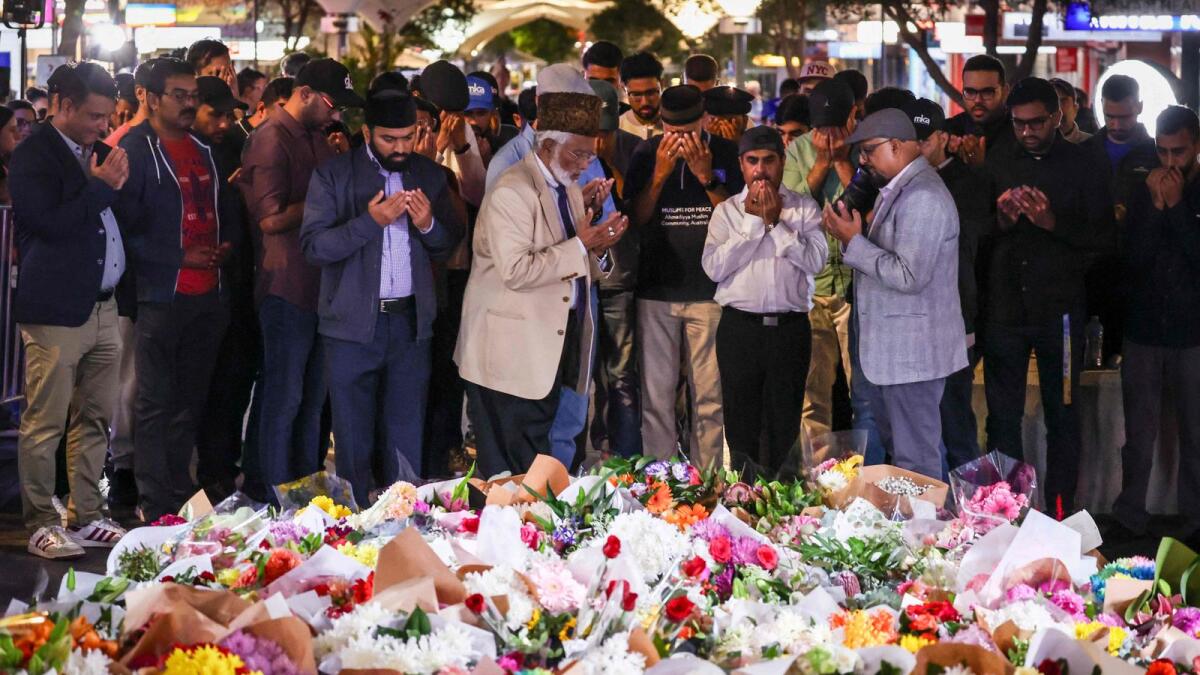 Members of the Ahmadiyya Muslim Community of Australia offer prayers in front of flowers left outside the Westfield Bondi Junction shopping mall in Sydney on Sunday, the day after a 40-year-old knifeman with mental illness roamed the packed shopping centre killing six people and seriously wounding a dozen others. — AFP
