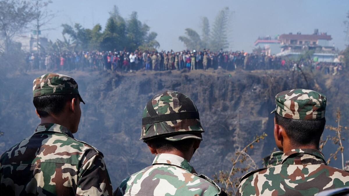Members of Nepal Army look towards the crash site of an aircraft carrying 72 people in Pokhara in western Nepal January 15, 2023.