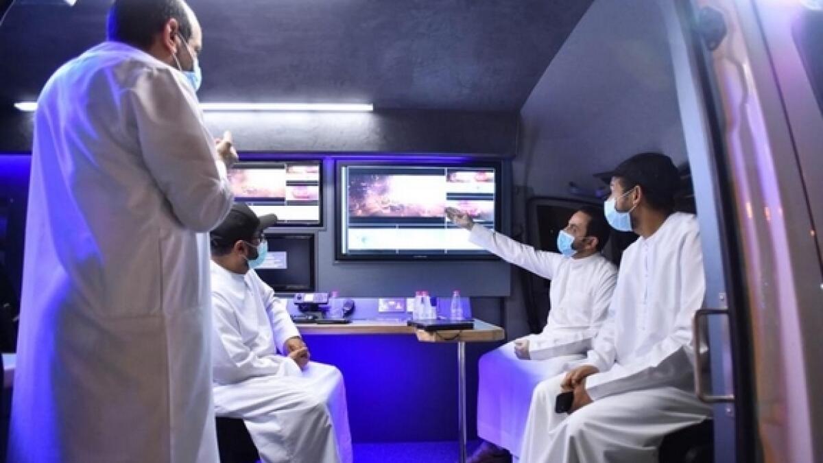 Tenants watch television footage of the blaze after being evacuated by Sharjah Civil Defence.