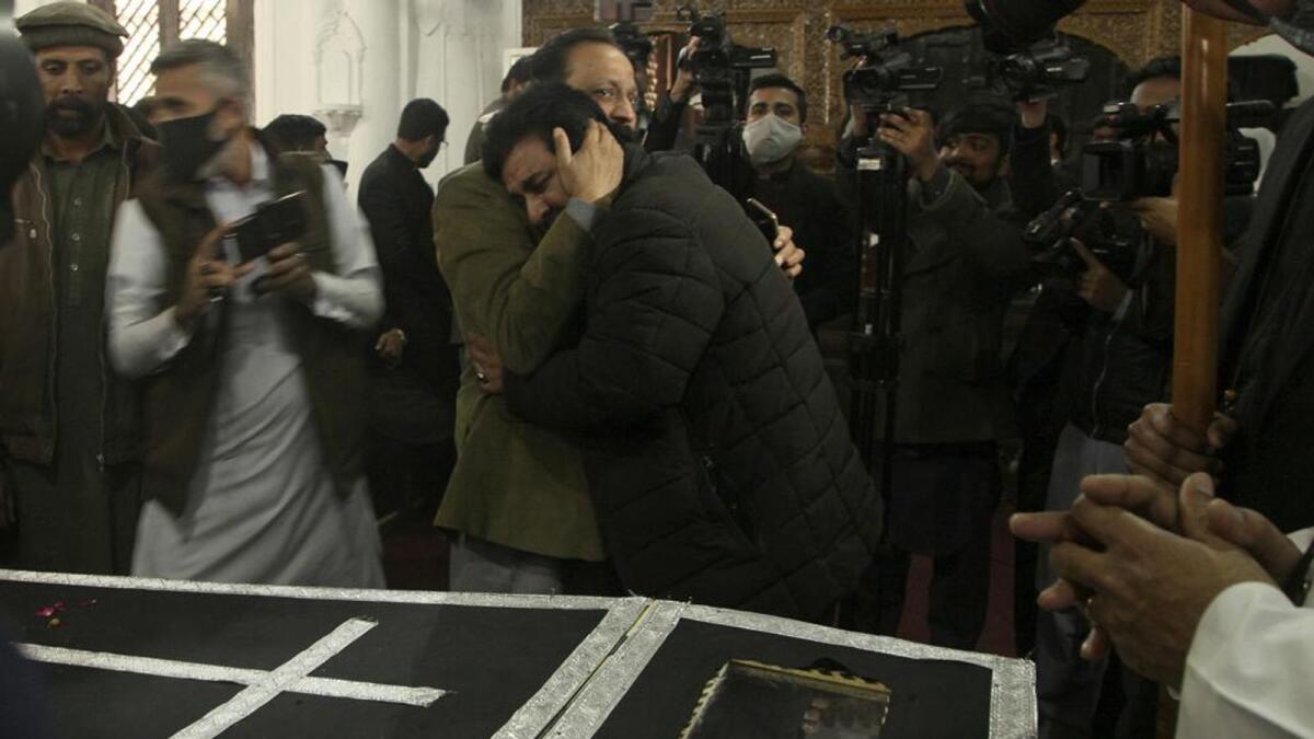 A man comforts a relative of Christian priest Father William Siraj, 75, who was killed by gunmen, during his funeral service at the All-Saints Church, in Peshawar, Pakistan, on Monday. —AP
