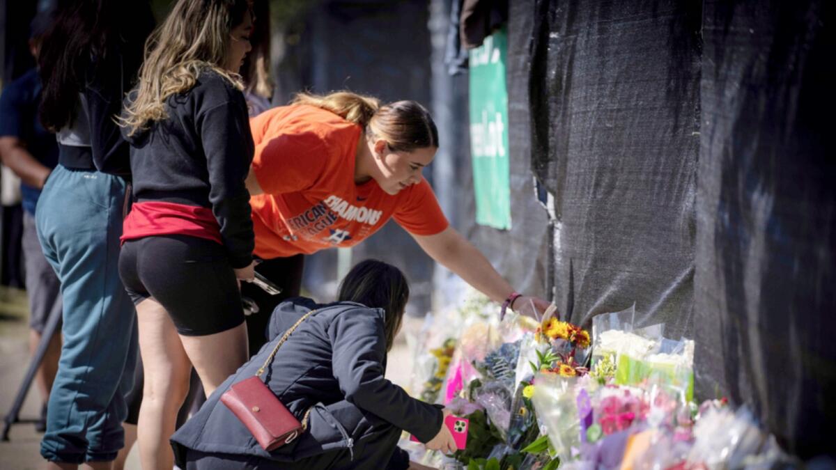 People place flowers at a memorial in Houston in memory of those who died in a crush of people at the Astroworld music festival on Friday. — AP