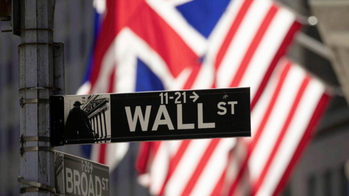 A Wall Street sign hangs in front of the New York Stock Exchange. — AP