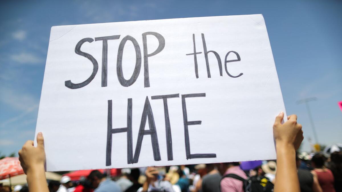 A demonstrator holds a sign reading 'Stop the Hate' at a protest against President Trump's visit following a mass shooting, which left at least 22 people dead, on August 7, 2019 in El Paso, Texas.