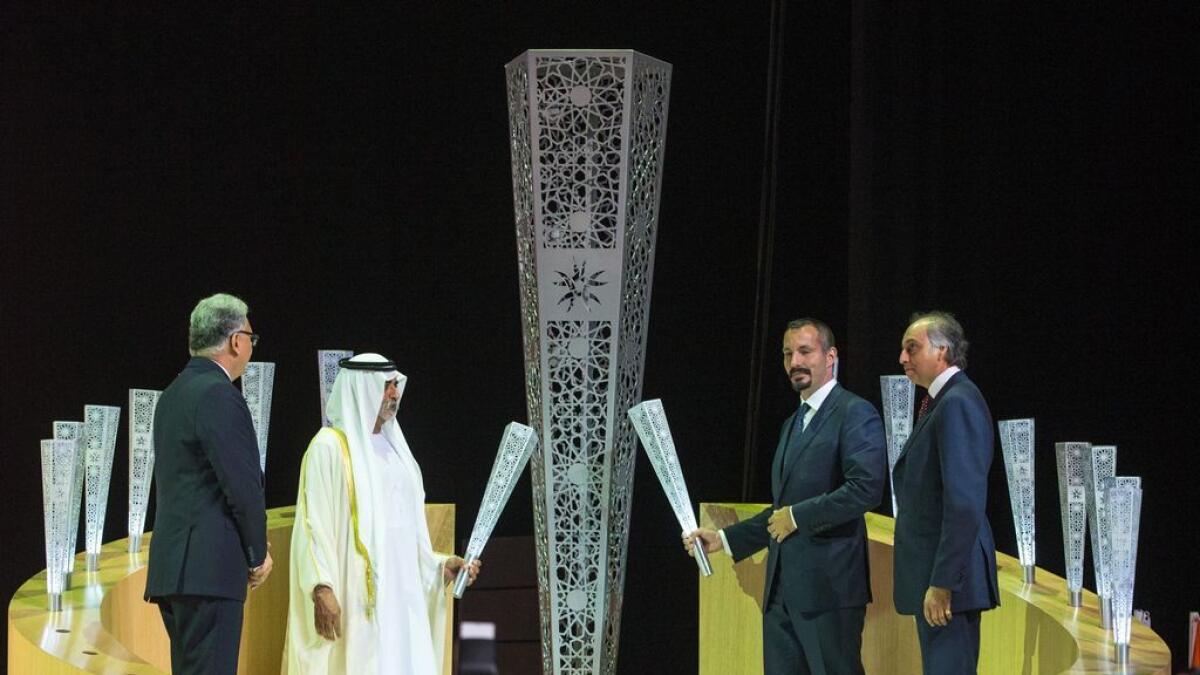 Shaikh Nahyan bin Mubarak Al Nahyan and Prince Rahim Aga Khan light a torch at the opening ceremony