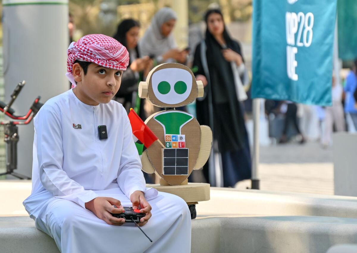 Ten-year-old Emirati boy Messed Salim Alkhuzaimi, with his MR COP robot at COP28 UAE, held at Expo City in Dubai on December 8, 2023. (Photo: M. Sajjad/Khaleej Times)