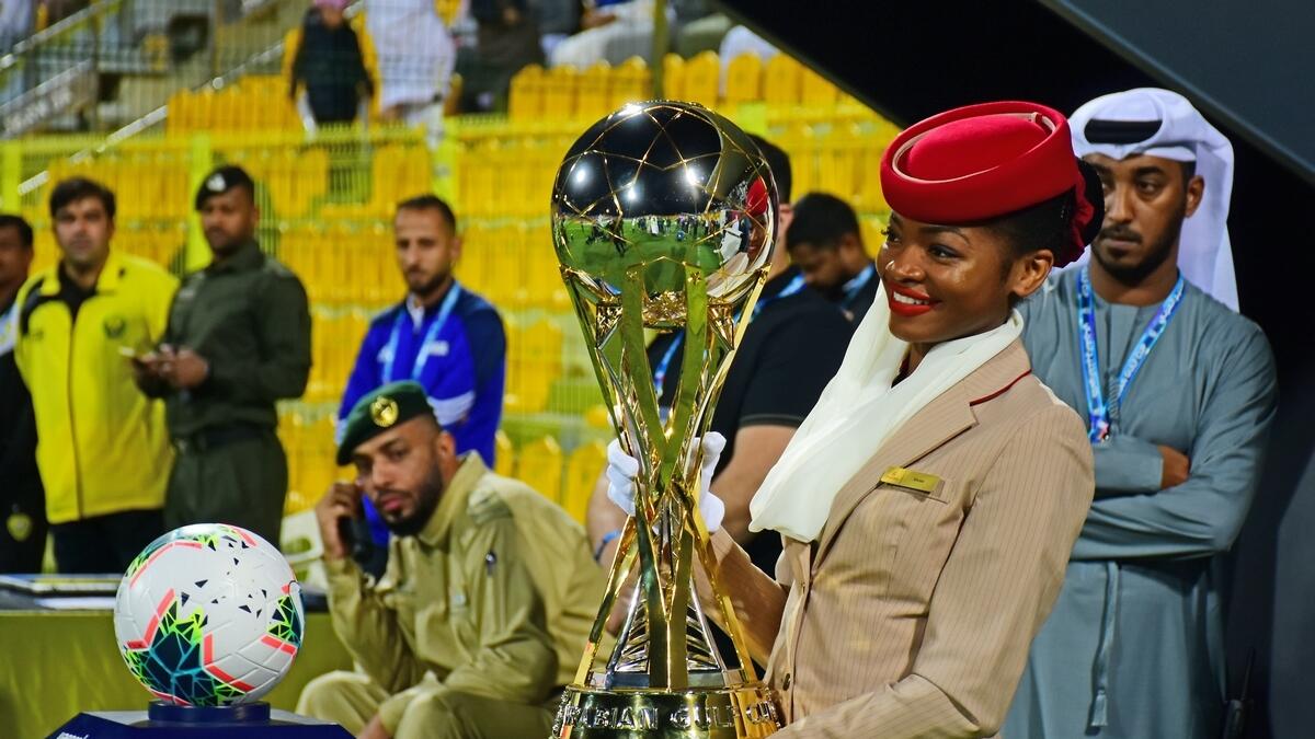 Emirates airline staff holds the official Arabian Gulf Cup trophy ahead of the final match