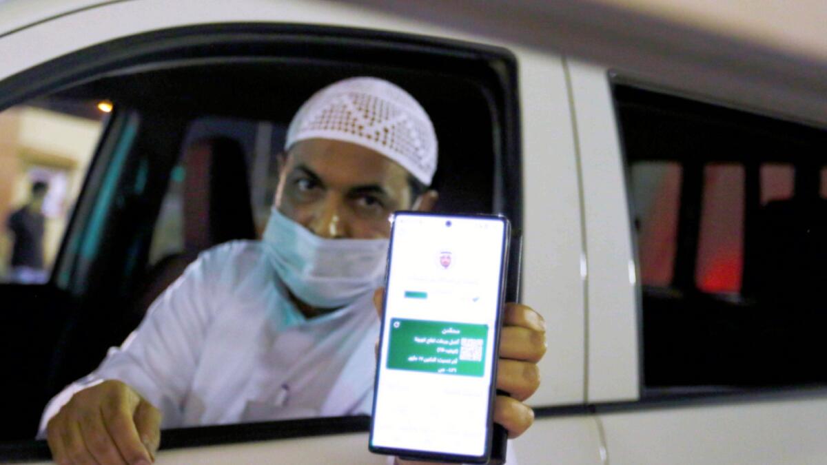 A Saudi national shows his vaccination certificate on his smartphone at Bahraini Immigration check-post as he enters Bahrain, after Saudi authorities lift the travel ban on its citizens after fourteen months, at King Fahad Causeway, Bahrain. — Reuters