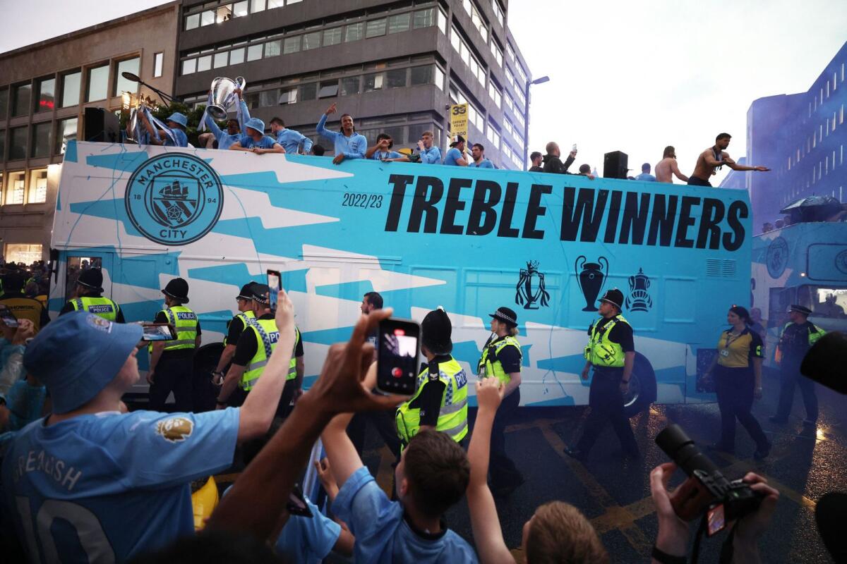 Manchester City's players on the bus as the parade is escorted through Manchester by police officers. — Reuters