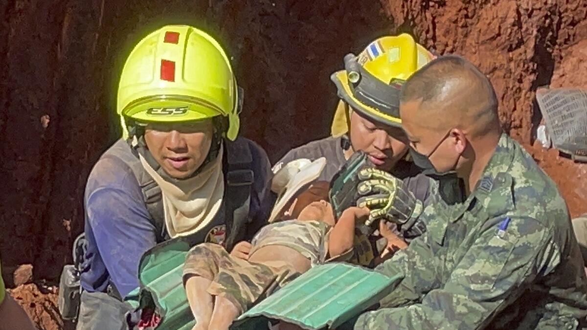 Following an overnight emergency operation, rescue workers and military carry the toddler from a deep hole in the northern Thailand province of Tak, 420kms north of Bangkok, on Tuesday. — AP