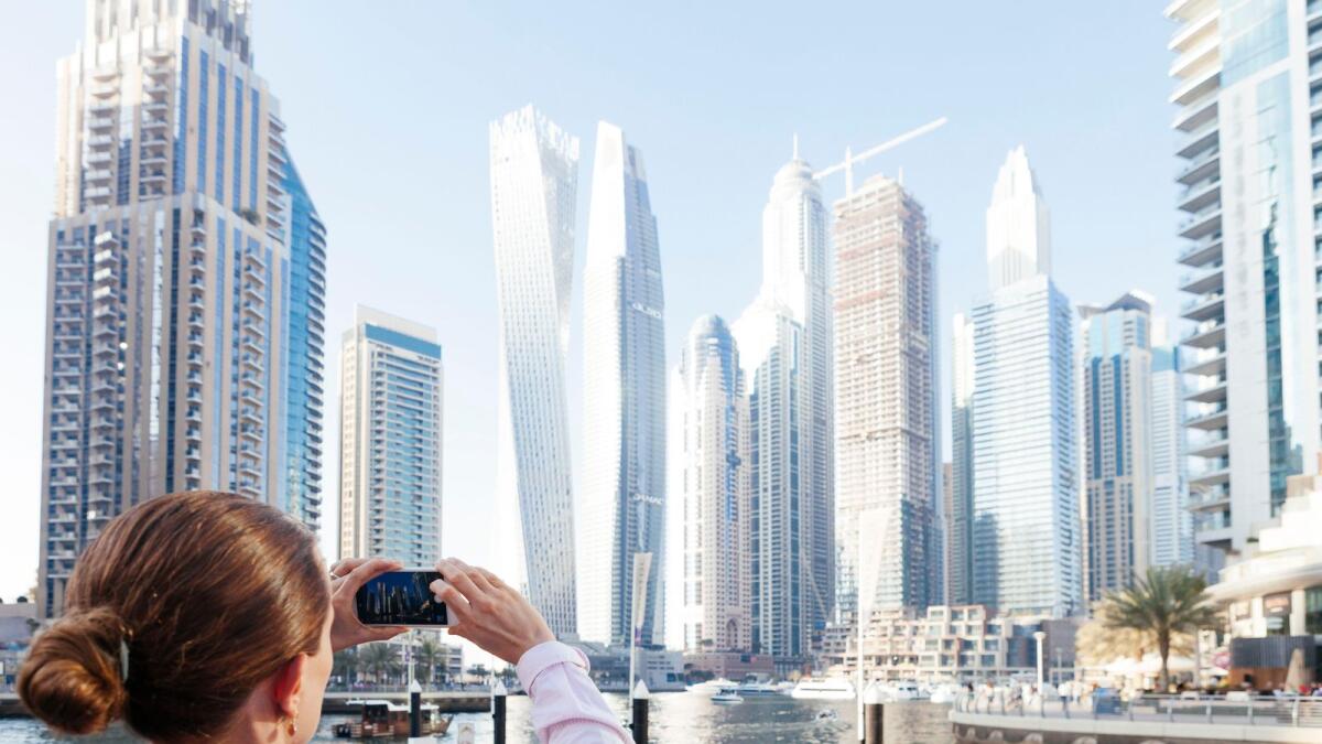 MJEDFE Dubai skyscrapers with Dubai Marina, female tourist taking a picture