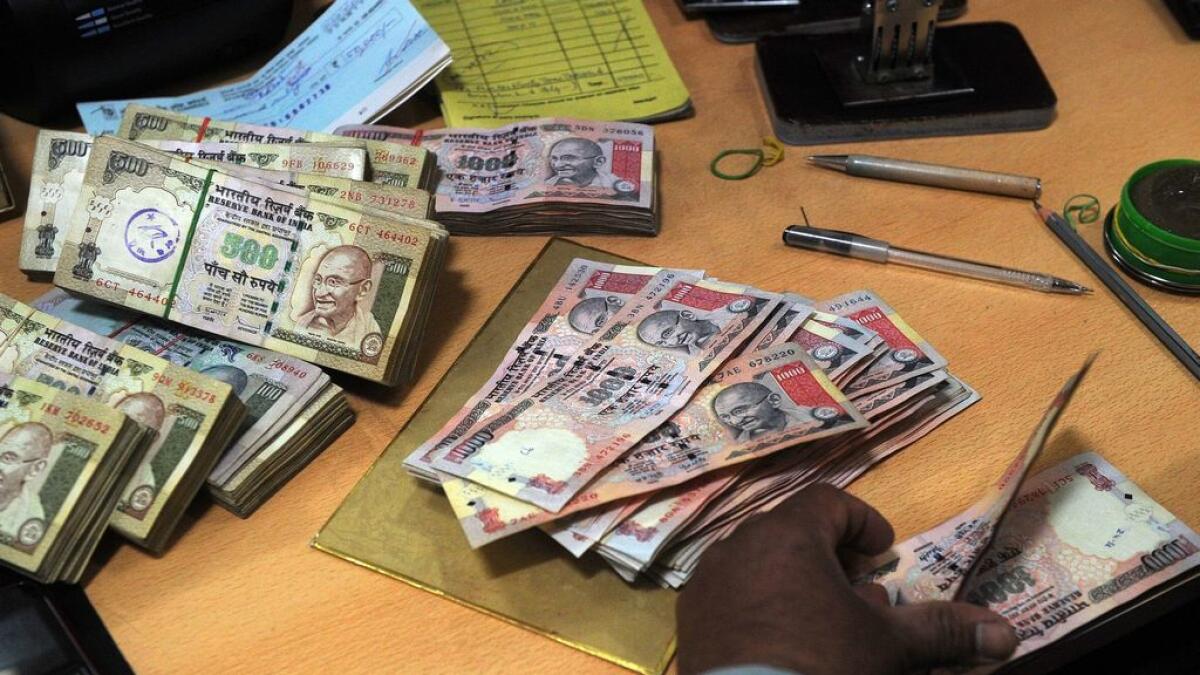 A person counts Indian rupee notes at a bank in Mumbai. 