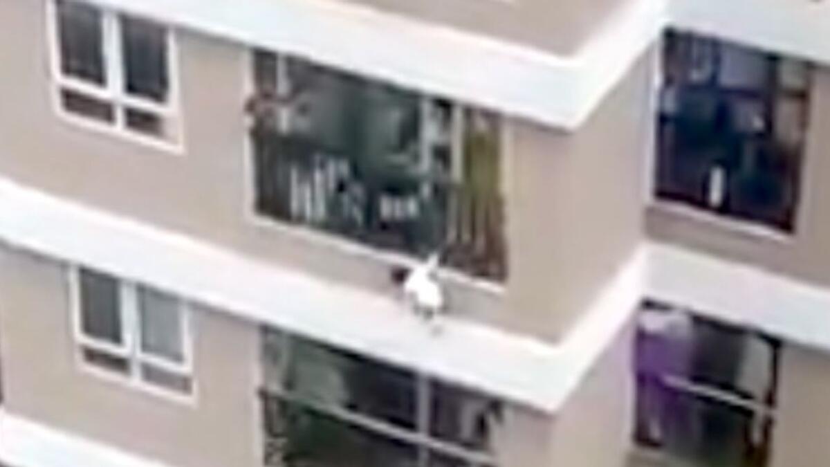 Screengrab from a video shows the baby dangling from her 12th-floor balcony.