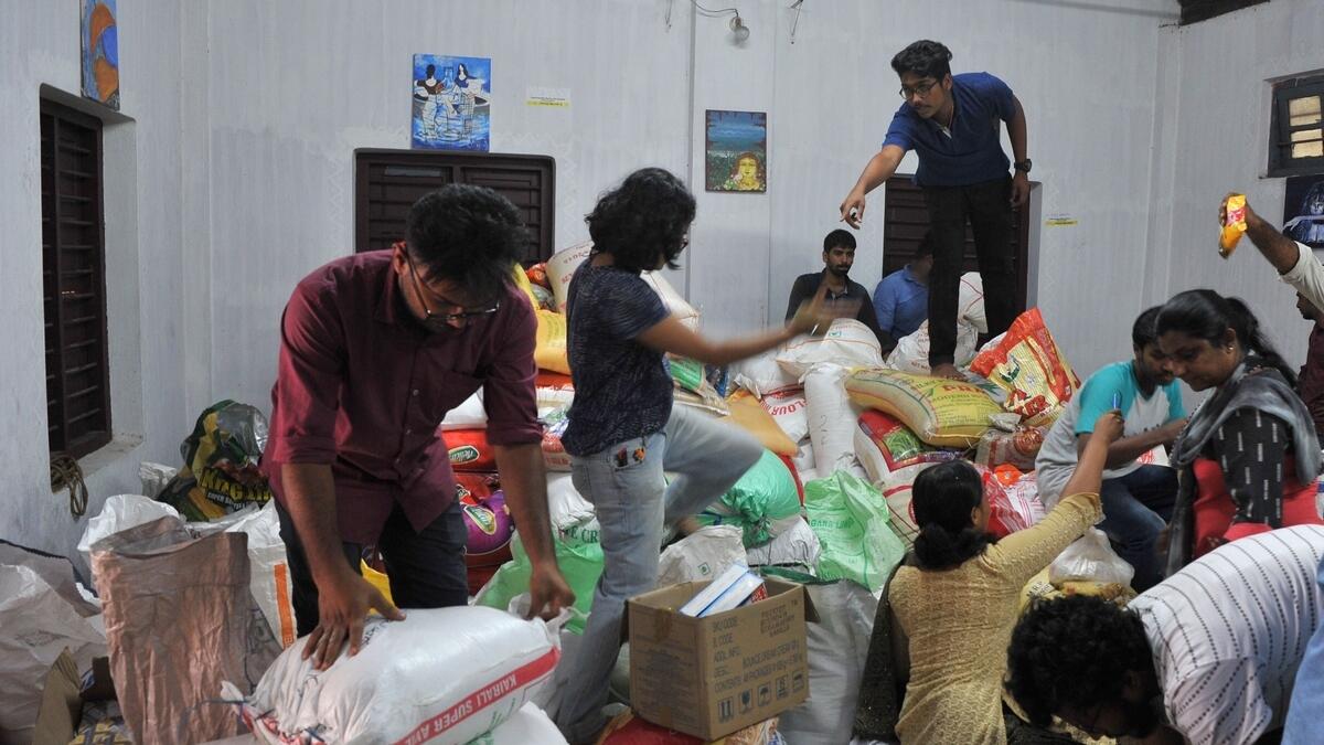 Volunteering members of the public help sort flood relief material at the District Tourism Promotion Council (DTPC), in Kozhikode district.- AFP
