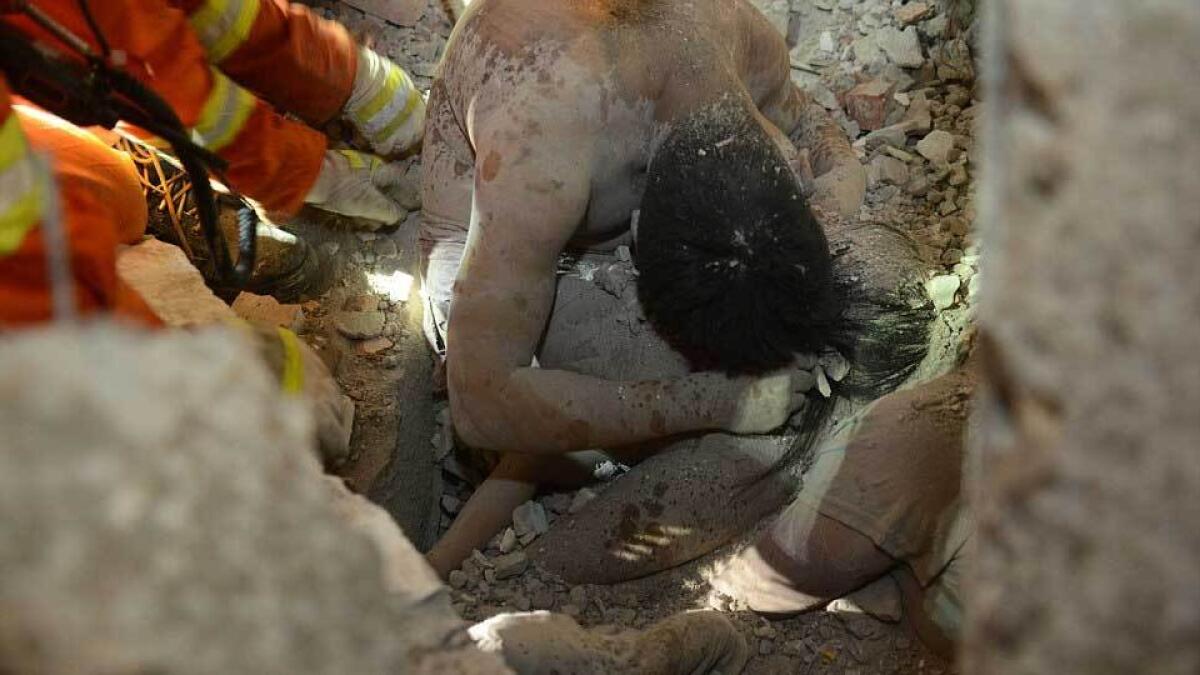 Dead fathers last embrace saves girl in China building collapse