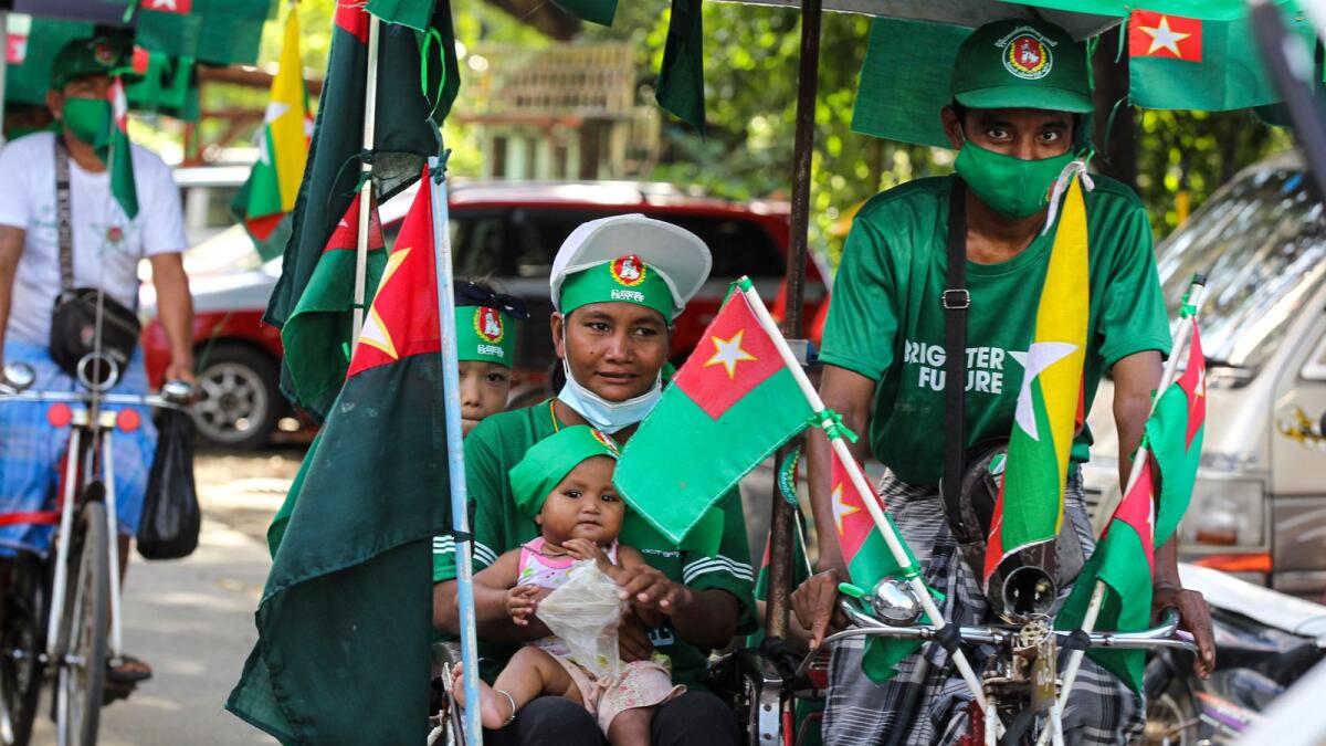 A supporter of the military-backed Union Solidarity and Development Party (USDP) holds a toddler while onboard a trishaw during an election campaign motorcade in Yangon, Myanmar, on Thursday.