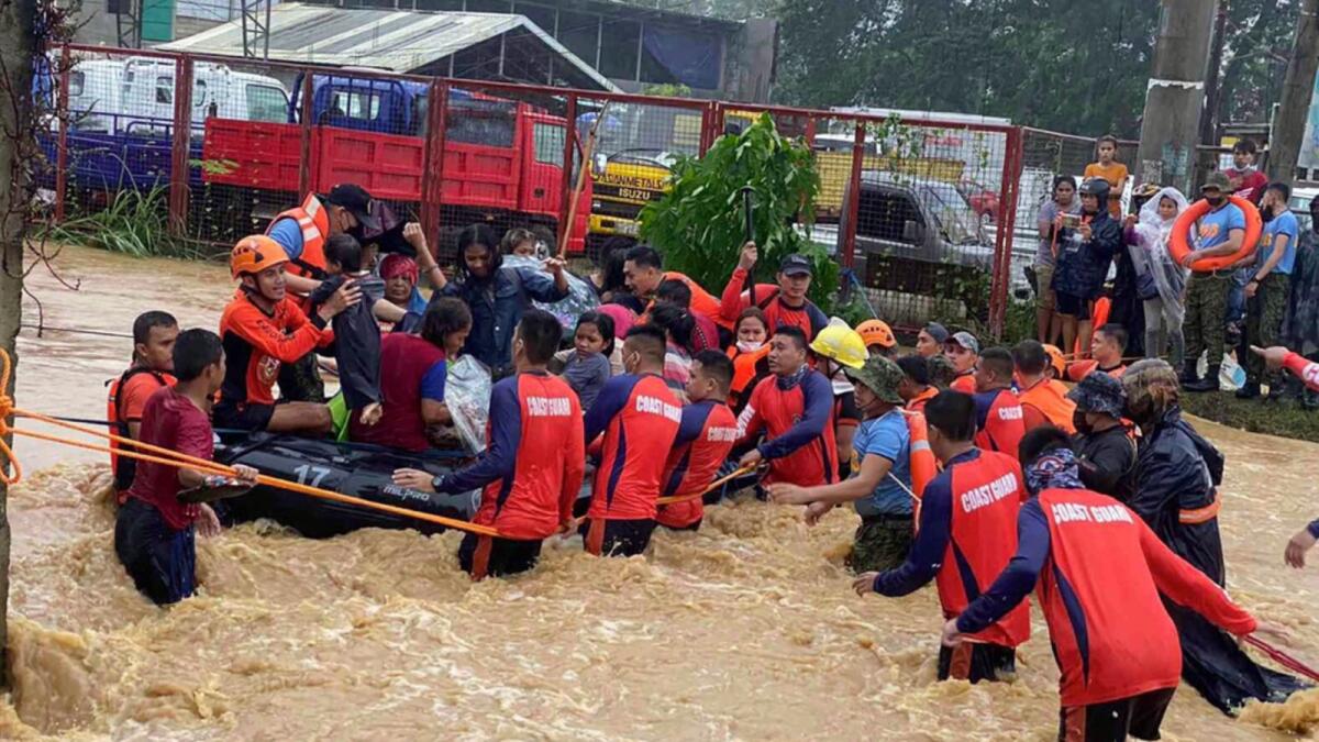 Rescuers assist residents over floodwaters caused by Typhoon Rai as they are evacuated to higher ground in Cagayan de Oro City, southern Philippines. — AP