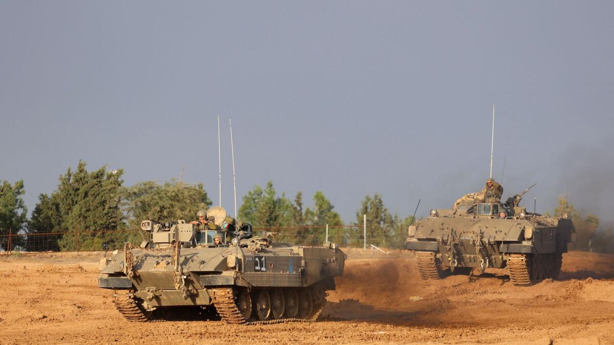 A picture taken from southern Israel near the border with the Gaza Strip on November 20, 2023, shows Israeli army vehicles driving towards the Palestinian enclave, amid ongoing battles. (Photo by AFP)
