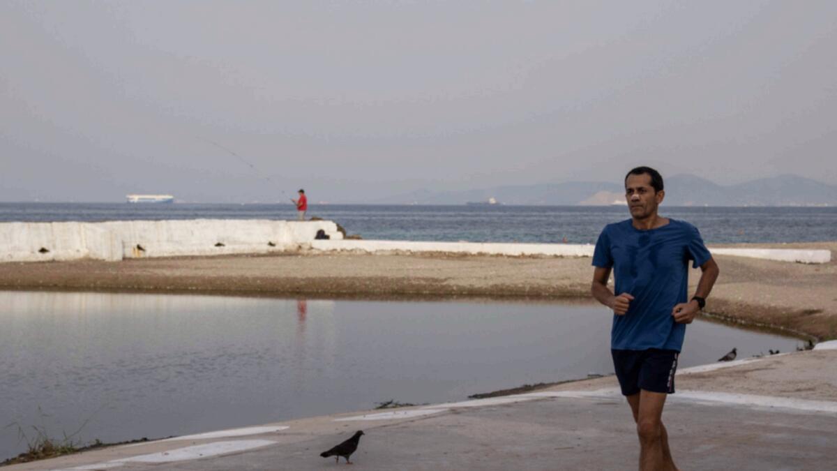 A man runs in the seaside suburb of the Alimos district of Athens. — AP