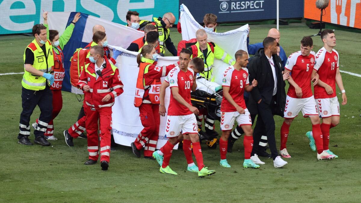 Denmark's players gather as paramedics attend to midfielder Christian Eriksen (not seen) during the Uefa EURO 2020 Group B football match between Denmark and Finland. — AFP