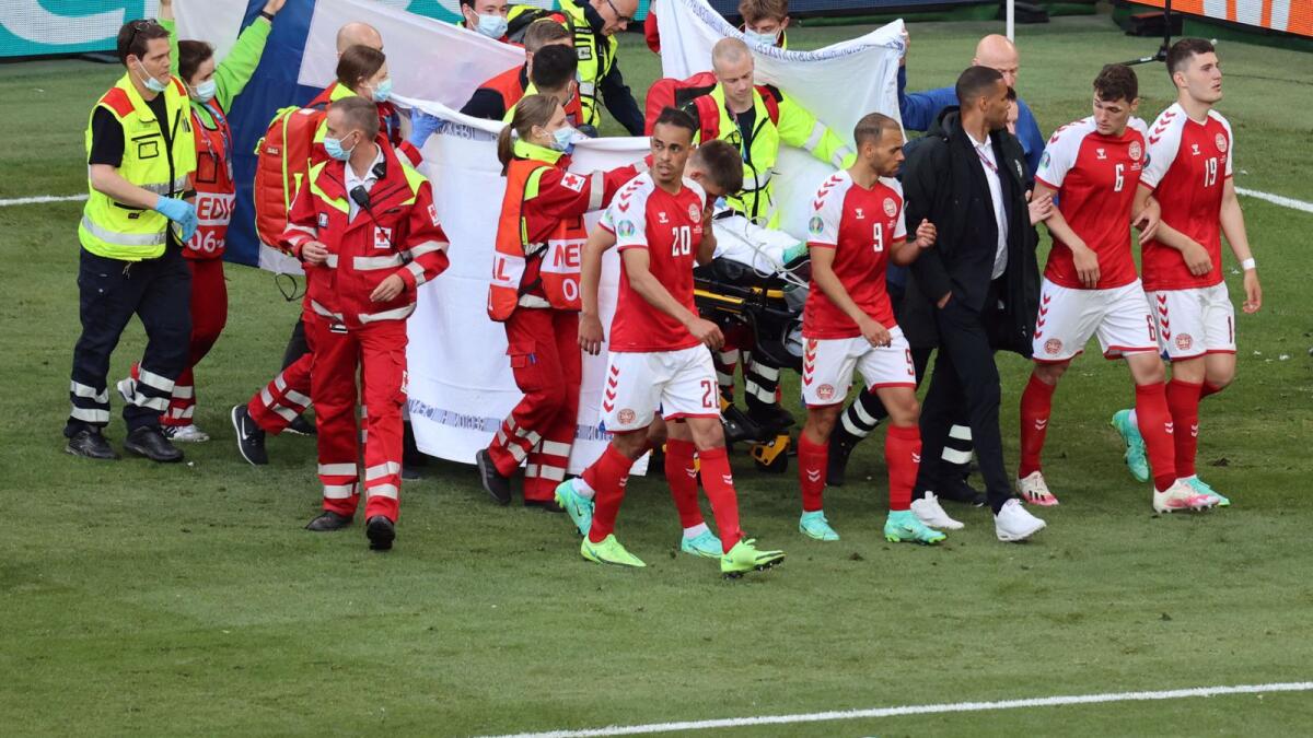 Denmark's players gather as paramedics attend to midfielder Christian Eriksen (not seen) during the Uefa EURO 2020 Group B football match between Denmark and Finland. — AFP