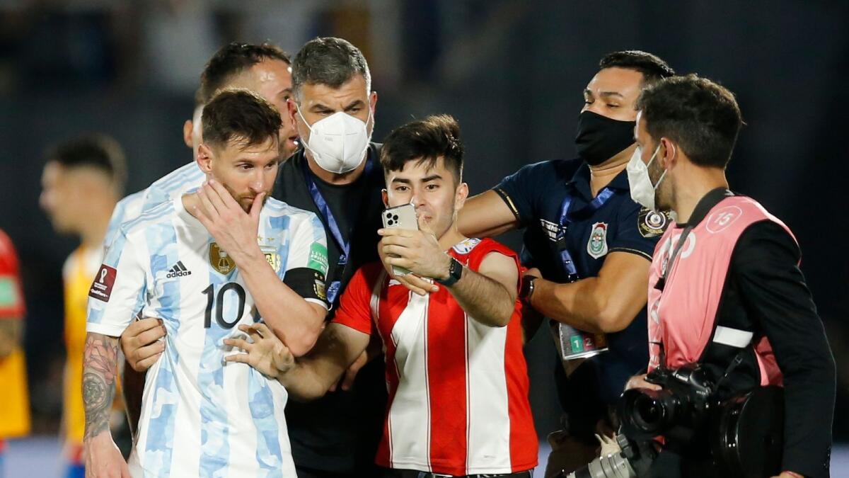 A Paraguyan fan tries to take selfie with Argentine star Lionel Messi after the match. — Reuters