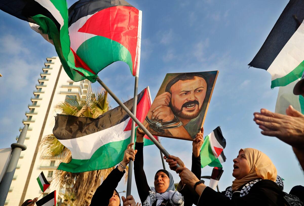 Palestinian women shout slogans while waving their national flags with a picture of jailed leader Marwan Barghouti during a protest in Beirut, Lebanon, on May 4, 2017. — AP file