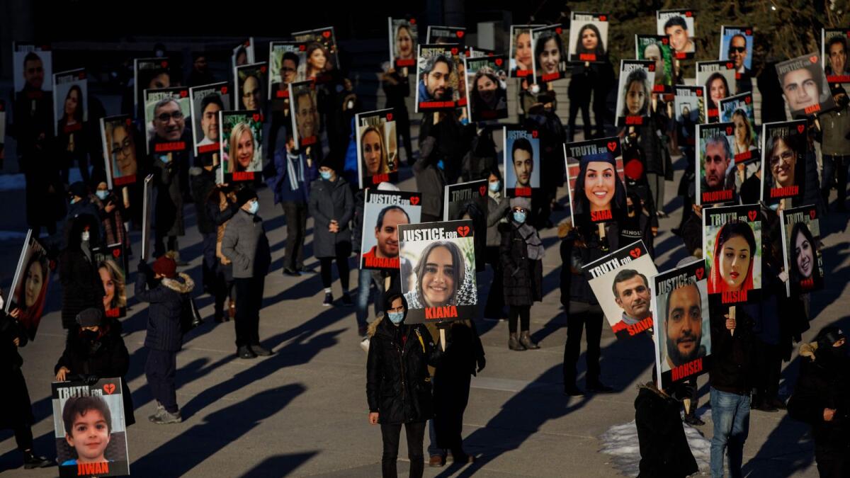 People hold signs with images of the victims of the downed Ukraine International Airlines flight PS752 in Toronto, Ontario, Canada. — AFP