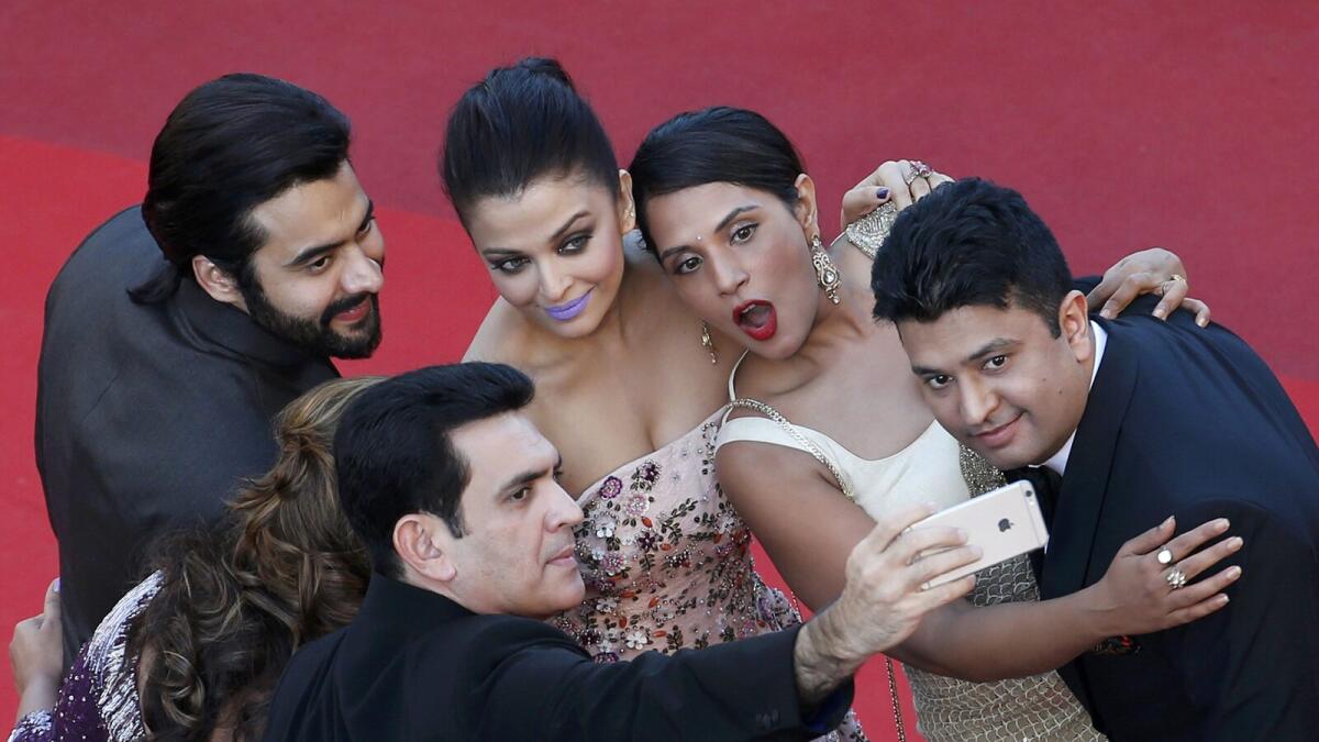Actress Aishwarya Rai (C) takes a selfie with guests as she arrives on red carpet for the screening of the film 'Mal de pierres' (From the Land of the Moon) in competition at the 69th Cannes Film Festival in Cannes, France, May 15, 2016.REUTERS/Jean-Paul Pelissier