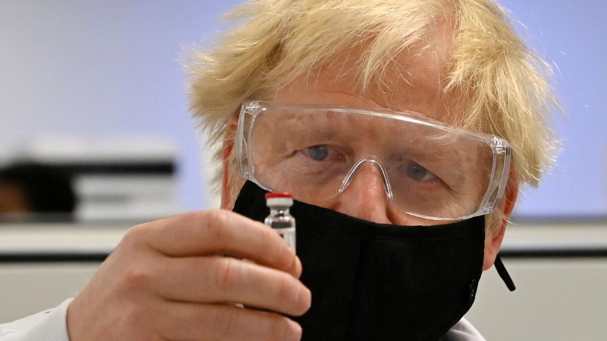 Britain's Prime Minister Boris Johnson poses for a photograph with a vial of the AstraZeneca/Oxford University COVID-19 candidate vaccine, known as AZD1222, at Wockhardt's pharmaceutical manufacturing facility in Wrexham, Wales, Britain November 30, 2020.