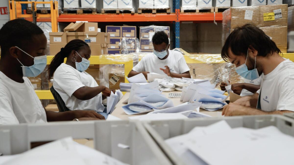 Operators prepare parcel posts containing protective face masks to be sent to precarious people at a logistics hub, a digital branch of the French postal service 'La Poste', in Buc near Paris, as part of a protective masks distribution for the most precarious. About 40 million protective masks will be delivered by mail and for free to French precarious families, eight million people in total, in the next 10 to 15 days by batches of six washable masks. Photo: AFP