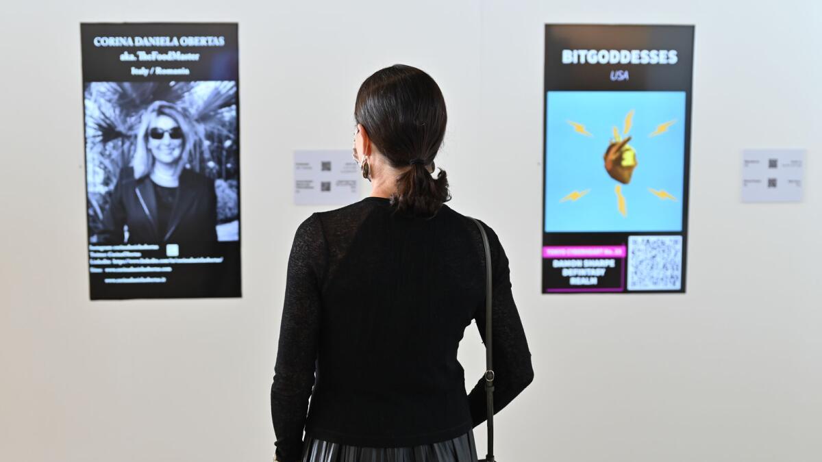 A visitor is looking at the digital artwork displayed at Sharjah's first NFT art exhibition, 'Gateway to the Metaverse' hosted by House of Wisdom - Photo by M. Sajjad