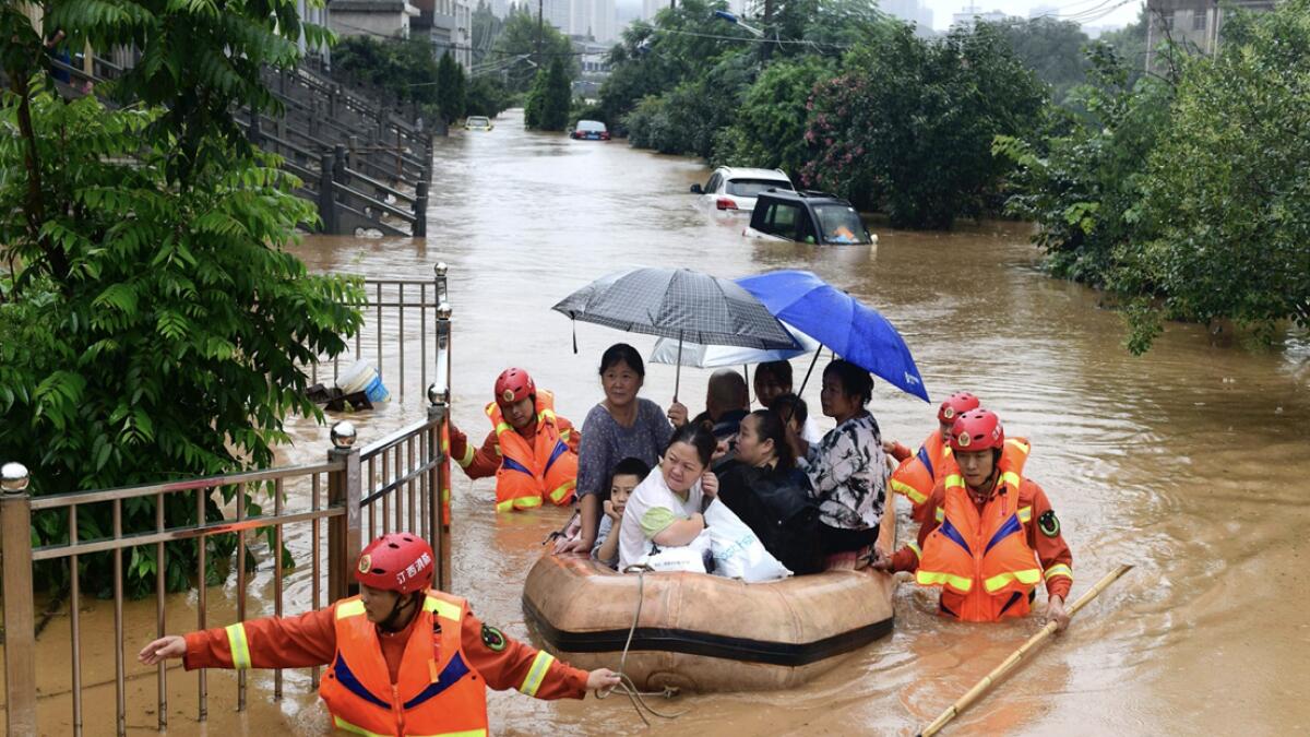 Rescuers evacuate residents on a raft through flood waters in Jiujiang in central China's Jiangxi province, China. Photo: AP